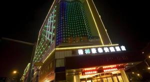 a tall building with lights on it at night at GreenTree Inn Fuzhou Dongxiang Longshan Express Hotel in Dongxiang