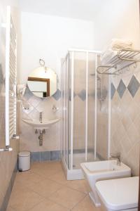 a bathroom with a shower and a toilet and a sink at Domo - Guest-House Il Nespolo Fiorito in Orosei