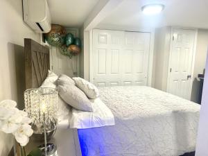 a bedroom with a bed with white sheets and pillows at Belmont Lux Escape - Walkable Studio 19 Miles to Manhattan in Elmont