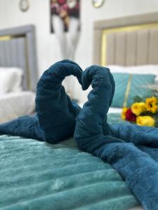 une paire de serviettes en forme de cœur sur un lit dans l'établissement Casa de Las Muñecas Recovery House, à Saint-Domingue