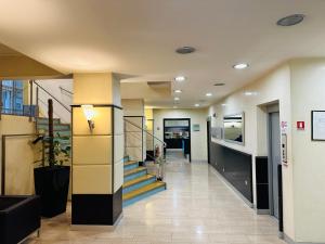 un couloir dans un bâtiment avec des escaliers et un hall dans l'établissement Hotel Kristall, à Corsico
