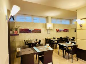 a dining room with tables and chairs in a restaurant at Hotel Kristall in Corsico