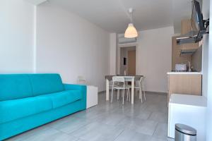 uma sala de estar com um sofá azul e uma mesa em Villa Vani Guest House em Marina di Ragusa