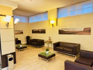 a lobby with couches and chairs and a table at Hotel Kristall in Corsico
