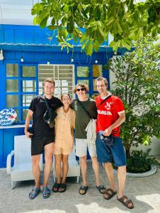 a group of people standing in front of a blue building at Moonbeam Homestay & Mini-resort Mui Ne in Phan Thiet