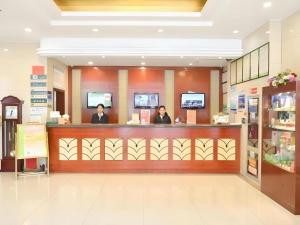 three people sitting at a counter in a store at GreenTree Inn Xuzhou High Speed Railway Station Express Hotel in Xuzhou