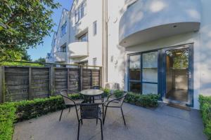 a patio with chairs and a table in front of a building at Elegant 3-Storey Townhouse with Garage Parking by Latimer Sq in Christchurch
