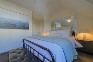 a bedroom with a large bed with a large mirror at Elegant 3-Storey Townhouse with Garage Parking by Latimer Sq in Christchurch