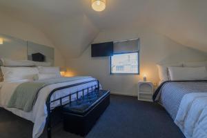 a attic bedroom with two beds and a window at Elegant 3-Storey Townhouse with Garage Parking by Latimer Sq in Christchurch +40 photos