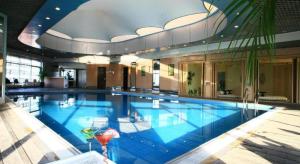 a large swimming pool in a large building at Jianguo Garden Hotel in Beijing