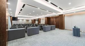 a large conference room with chairs and a white screen at Yitel Collection Hefei Changjiang Hotel Sanxiaokou Metro Station in Hefei
