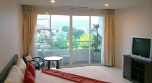 a bedroom with a bed and a large window at Hua Hin Avenue Hotel in Hua Hin