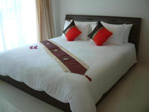 a bedroom with a bed with red pillows and a white bedspread at Hua Hin Avenue Hotel in Hua Hin +172 photos