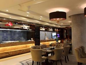 a restaurant with tables and chairs and a bar at Xiamen Airlines Quanzhou Hotel in Quanzhou
