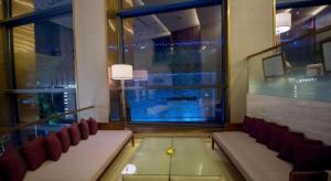 Una habitación con una mesa y sillas y una ventana. en Wojo Hotel, en Tashan