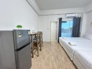 a small room with two beds and a table at Comfy Hotels Suvarnabhumi Airport in Samut Prakan +83 photos