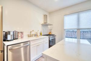 a kitchen with white cabinets and a stainless steel refrigerator at Stay Portland - Historic Queen Anne Vernacular - 95 WalkScore in Portland +33 photos