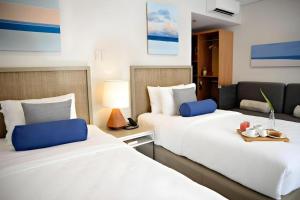 twee bedden naast elkaar in een kamer bij HUNI LIO in El Nido Airport +52 foto's