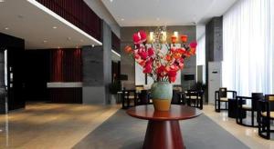 a vase of flowers on a table in a lobby at Jinjiang Inn Kunming Changshui Airport in Kunming