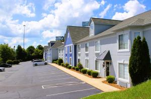 a row of apartment buildings with a parking lot at Quality Inn Crossville Near Cumberland Mountain State Park in Crossville
