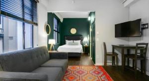 a living room with a bed and a couch and a television at The Oxford Seattle-Downtown in Seattle