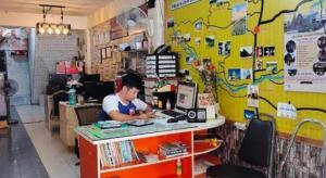 a woman sitting at a table in a book store at Sofia Hostel in Chiang Rai