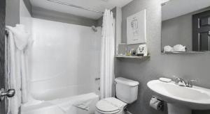 a white bathroom with a toilet and a sink at The Oxford Seattle-Downtown in Seattle +158 photos