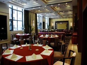 a restaurant with red tables and chairs and a screen at Lhasa Hotel in Lhasa