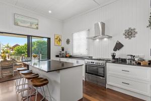 een witte keuken met een aanrecht en krukken. bij Prime Position in Scarborough in Scarborough