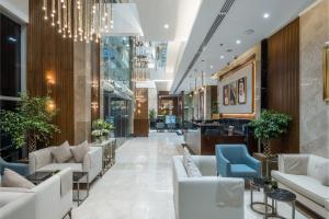 a lobby with white furniture and a chandelier at Three Pearls Musalli Hotel in Makkah