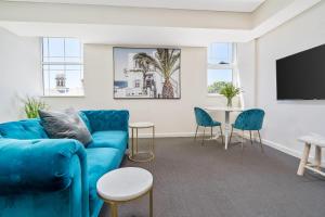 a living room with a blue couch and a table at Terminus Apartment Hotel, an Ascend Collection Hotel in Newcastle