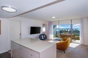 a living room with a table and a couch and a television at Terminus Apartment Hotel, an Ascend Collection Hotel in Newcastle