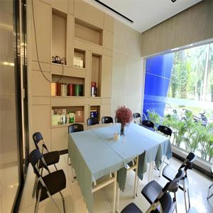 a dining room with a blue table and chairs at Echarm Hotel Nanning Nationalities Square Metro Station in Nanning