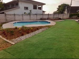 a backyard with a pool and green grass at Ocean Wave Chalets Unit 1 in Hibberdene