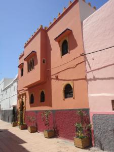 a brick building with a red and white painted wall at Dar Yanis in Rabat