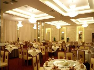 a dining room with tables and chairs in a restaurant at Hot Spring Hotel in Beijing +189 photos