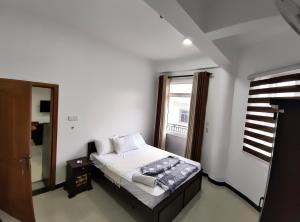 a bedroom with a bed and a window in a room at KBK Furnished Apartments, Digana in Gomagoda