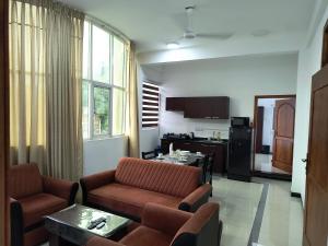 a living room with couches and a table and a kitchen at KBK Furnished Apartments, Digana in Gomagoda