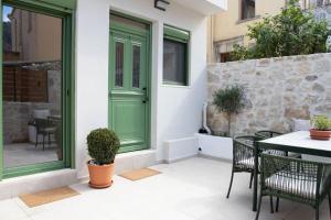 a green door on a house with a table and chairs at Alexandra Heritage Μaison in Archanes