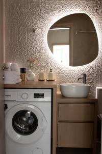 a bathroom with a washing machine and a sink at Alexandra Heritage Μaison in Archanes