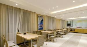 a restaurant with tables and chairs and a kitchen at City Comfort Inn Xiaogan Chengzhan Road in Xiaogan