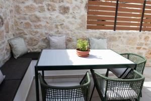 a table and chairs with a potted plant on it at Alexandra Heritage Μaison in Archanes +9 photos
