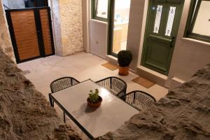a table and chairs with a potted plant on it at Alexandra Heritage Μaison in Archanes
