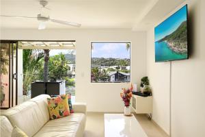 a living room with a couch and a large window at St Tropez 8 - Waterfront Retreat with Rooftop Spa & Sauna in Noosa Heads