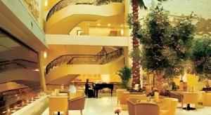 a restaurant with tables and chairs and a grand piano at Fujian Hotel in Beijing