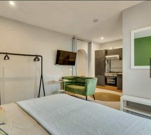 a bedroom with a bed and a green chair at Sueño Grande in Lliber