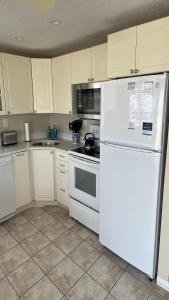 a kitchen with white cabinets and a white refrigerator at Holgate Ocean Front Duplex 2Nd Fl 14018 in Holgate