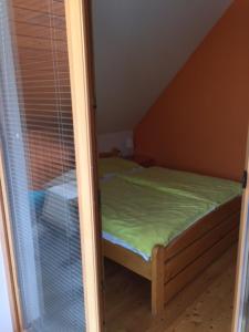a small bed in a room with a window at Alpine Spot in Kranjska Gora