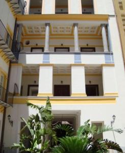 a white building with blue and yellow trim at Terrazze Ginevra in Palermo