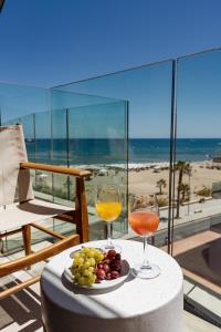 レティムノ・タウンにあるKriti Beach Hotelのワイン2杯とフルーツプレート付きテーブル
